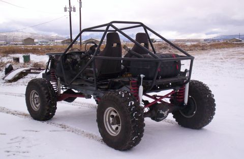 1984 Ford Bronco - A custom-built off-road buggy with a roll cage sits in a snowy landscape.