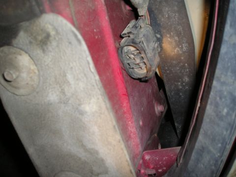 1997 Ford F-250 - A close-up view of a vehicle's electrical connector and part of its red body panel.