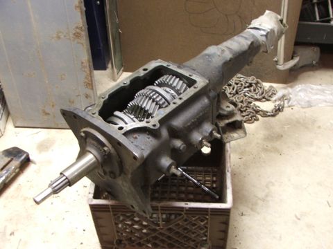 1965 Ford Mustang - A transmission part is shown with its internal gears visible, placed inside a crate.