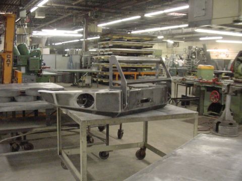 1993 Ford Bronco - A custom-fabricated bumper is shown on a cart in a manufacturing facility.