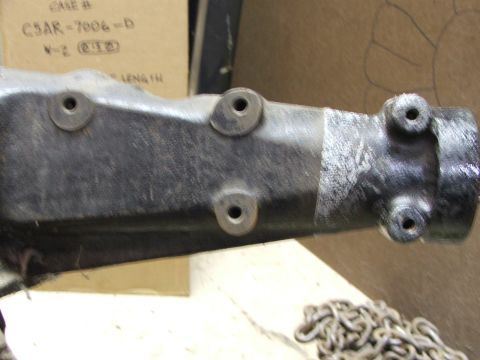 1965 Ford Mustang - Close-up of a black automotive part with visible bolt holes and a silver metal end.