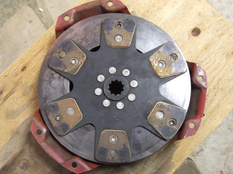1965 Ford Mustang - A clutch disc assembly, likely for a vehicle, is shown from a top-down perspective on a wooden surface.