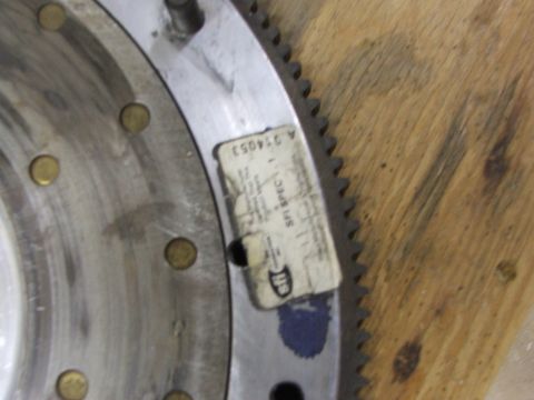 1965 Ford Mustang - Close-up of a metal flywheel with a SFI SPEC 1 label, part number A 354053, on a wooden surface.