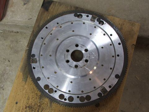 1965 Ford Mustang - This aluminum flywheel features a toothed ring gear around its perimeter, indicating its function in an engine's drivetrain.