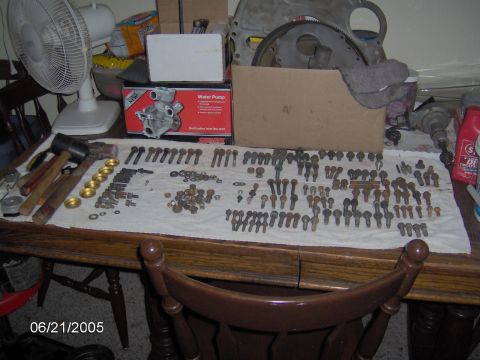 1978 Ford Bronco - A collection of automotive parts and tools are laid out on a table, suggesting a rebuild or repair project.