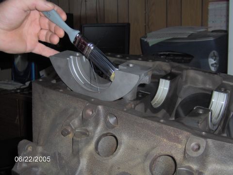 1978 Ford Bronco - Applying assembly lube to main bearing caps before installation on engine block.