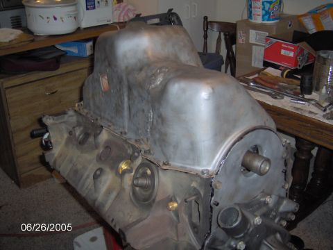 1978 Ford Bronco - Close-up of an engine block and its oil pan, with tools and household items visible in the background.