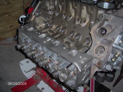 1978 Ford Bronco - Close-up of an engine block, showing the valves and springs, mounted on a red engine stand.