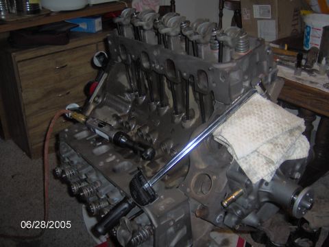 1978 Ford Bronco - Engine block assembly in progress, with a torque wrench being used on the valve train components.