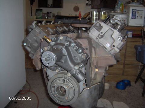 1978 Ford Bronco - Engine assembly in a workshop setting, with tools and shelves in the background.