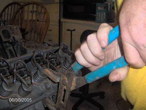 1978 Ford Bronco - A mechanic uses pliers to work on the valve train of an engine, with a date stamp of 06/30/2005 visible.