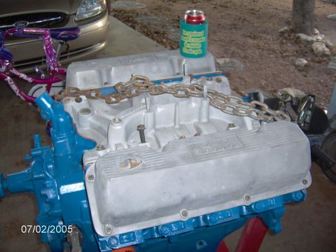 1978 Ford Bronco - A Ford Motorsport engine is shown with a blue block and silver valve covers, with a chain draped over the intake manifold.