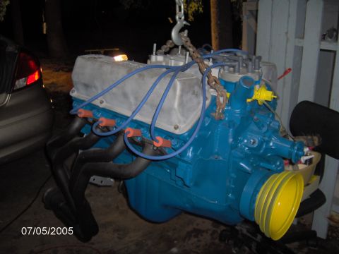 1978 Ford Bronco - Engine being hoisted, painted blue with black headers and a yellow pulley visible.