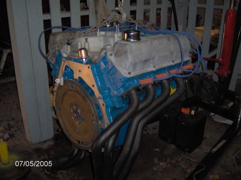 1978 Ford Bronco - Engine block with headers and valve covers, suspended by chains.