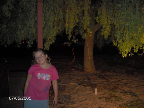 1978 Ford Bronco - A young girl smiles for the camera in a backyard setting at night, with a tree and foliage in the background.
