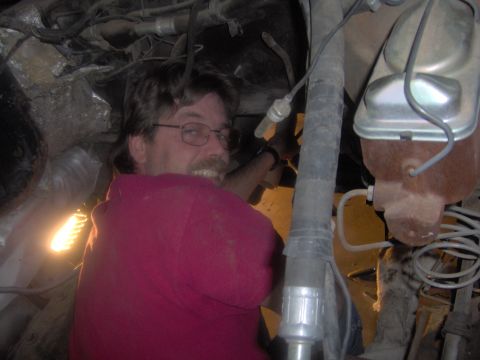 1978 Ford Bronco - Man working on vehicle engine bay, brake fluid reservoir is visible.
