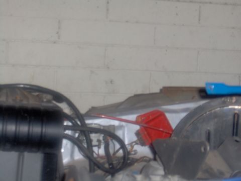 1978 Ford Bronco - Close-up view of an engine bay, showing a black air intake, various hoses, and a red container.