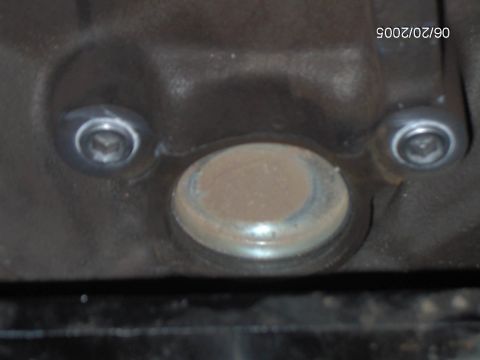 1978 Ford Bronco - Close-up of an engine component, possibly a plug or cap, secured by two bolts. A date stamp is visible in the upper right corner.
