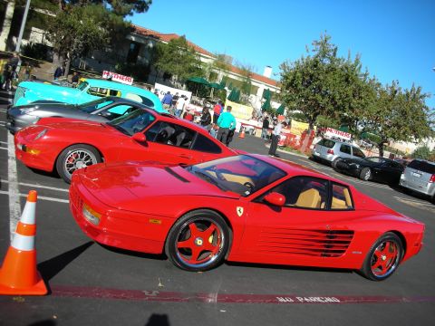 1992 Ford Crown Victoria - Several cars are parked in a lot, including a red Ferrari and a grey Porsche, with a turquoise car behind them.