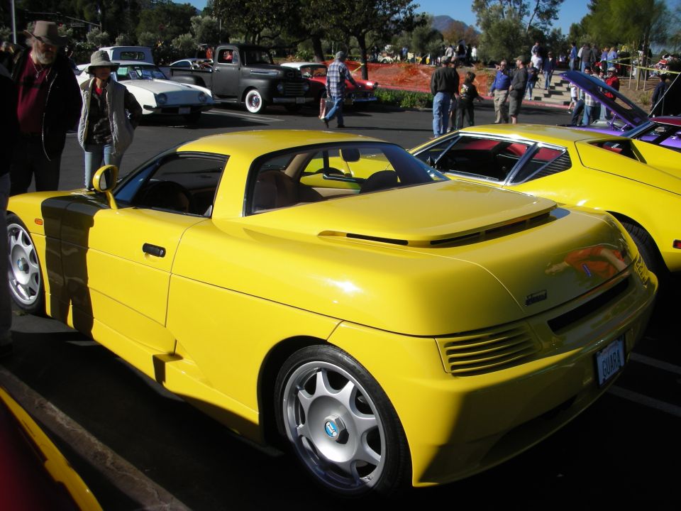 Yellow sports car rear view with distinctive louvers and a spoiler
