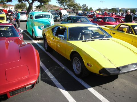 1992 Ford Crown Victoria - A bright yellow sports car is parked at a car show, with other vehicles visible in the background.