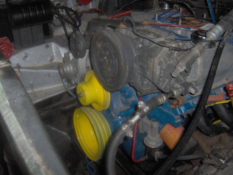 1978 Ford Bronco - Close-up view of engine components, including belts and pulleys, in a vehicle's engine bay.