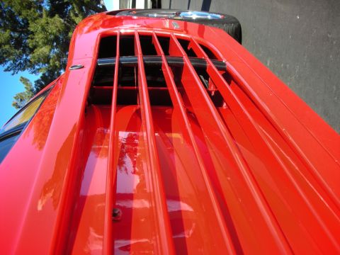 1992 Ford Crown Victoria - Close-up of a red sports car's rear decklid, showing its distinctive louvered design.