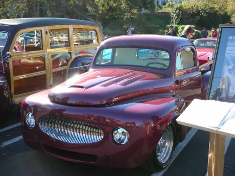 1992 Ford Crown Victoria - A custom pickup truck with a distinctive grille is displayed next to a classic woodie wagon.