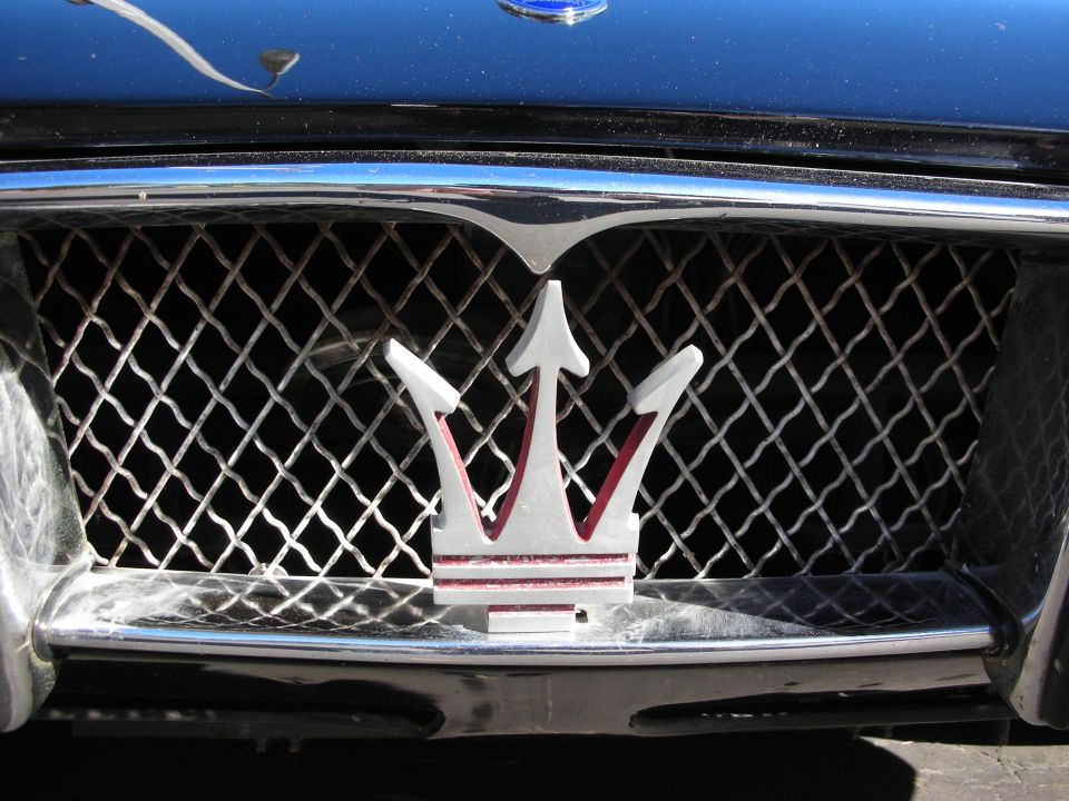 Close-up of a Maserati trident emblem on a car's front grille