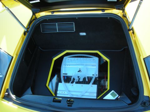 1992 Ford Crown Victoria - The trunk of a yellow car is open, revealing custom audio equipment with a prominent Lamborghini logo.