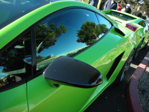 1992 Ford Crown Victoria - A bright green sports car is parked next to another vehicle, with trees reflected in its window.