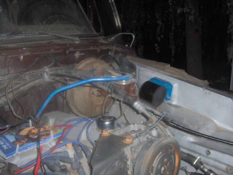 Engine bay showing brake booster, master cylinder, and wiring. A book is visible on the left