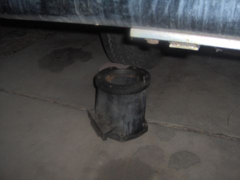 1978 Ford Bronco - Exhaust pipe flange shown on the ground beneath a vehicle's frame.