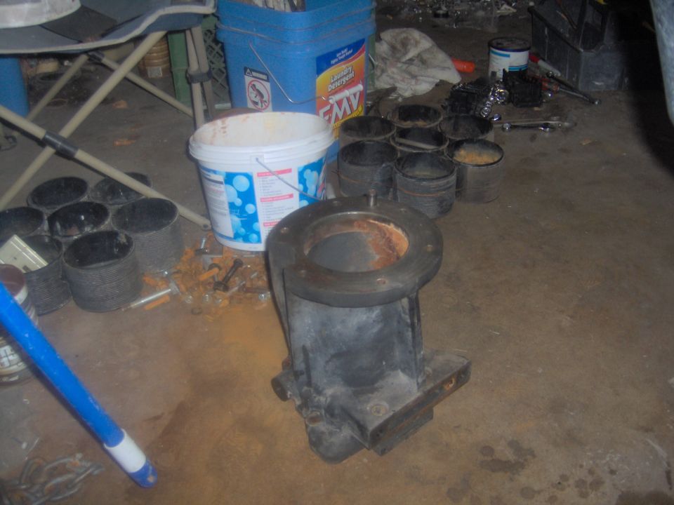 Engine part on floor with buckets and tools nearby. Supermotors.net logo visible
