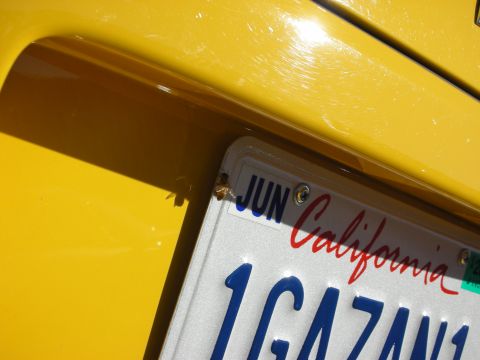 1992 Ford Crown Victoria - A close-up view of a yellow vehicle's rear quarter panel, a California license plate.