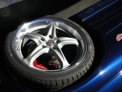 1992 Ford Crown Victoria - A close-up of a silver wheel and a portion of a blue car's fender is visible.