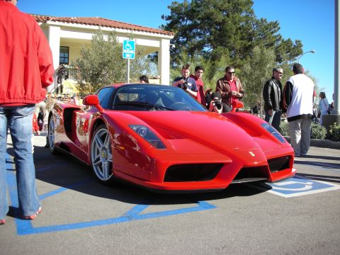 1992 Ford Crown Victoria - A bright red Ferrari Enzo is parked in a handicapped spot, drawing attention from onlookers.