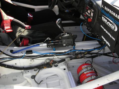1992 Ford Crown Victoria - Interior view of a racing car, highlighting the shifter mechanism, fire suppression system, and sponsor decals.