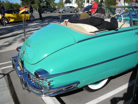 1992 Ford Crown Victoria - A turquoise convertible is parked in a lot, with a person relaxing in the passenger seat.