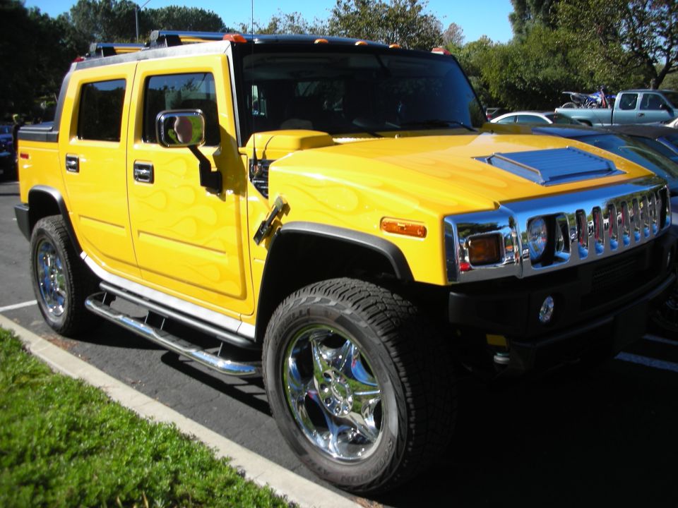 Yellow Hummer H2 with flame graphics and chrome wheels