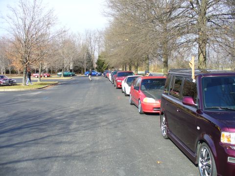 1991 Ford Probe - A line of cars is parked on a paved lot, with a purple SUV in the foreground.