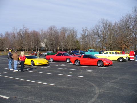 1991 Ford Probe - A red sports car is parked in a lot alongside other vehicles, including a yellow classic car and a red pickup truck.