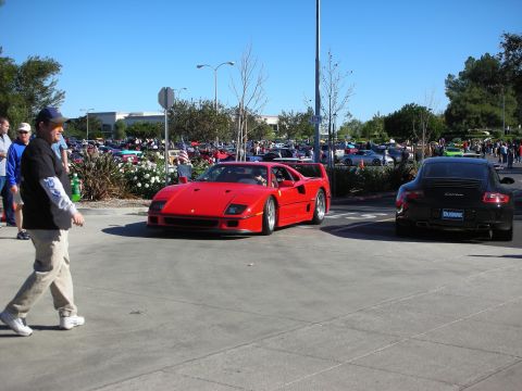 1992 Ford Crown Victoria - A bright red Ferrari F40 is the center of attention at an outdoor car gathering.