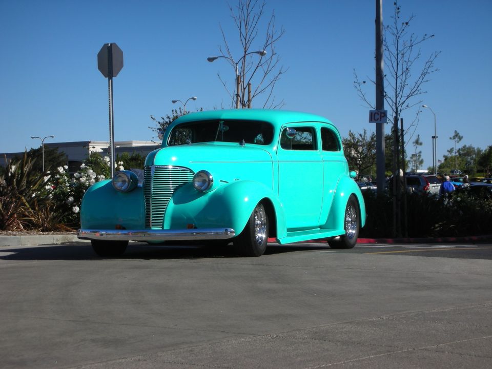 Turquoise hot rod sedan parked outside on a sunny day