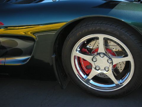 1992 Ford Crown Victoria - Close-up of a car's wheel and fender shows custom chrome rims and red brake calipers.