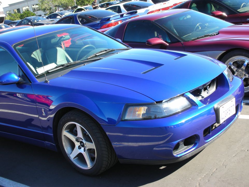 Blue Ford Mustang front 3/4 view, showing hood scoops and grille