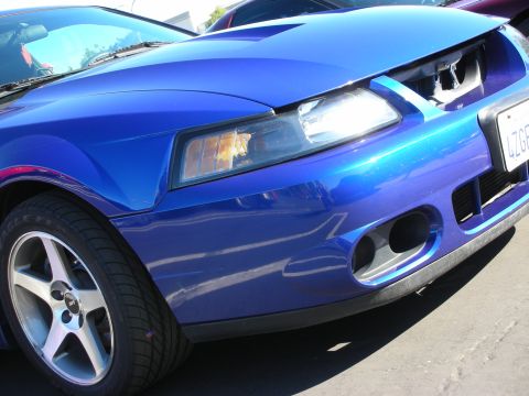1992 Ford Crown Victoria - Front view of a blue Ford Mustang, with another vehicle in the background.