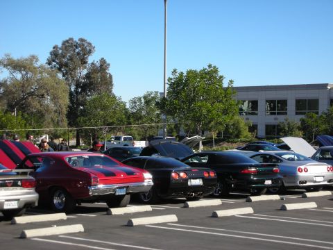 1992 Ford Crown Victoria - A red 1969 Chevrolet Chevelle SS is parked alongside other vehicles in a lot.