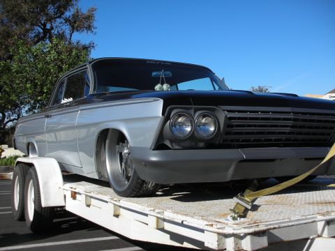 1992 Ford Crown Victoria - This customized classic car is being transported on a trailer, showing its unique two-tone paint job and front grille.