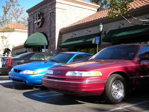 1992 Ford Crown Victoria - Three cars are parked in front of a commercial building with a BJ's restaurant sign.